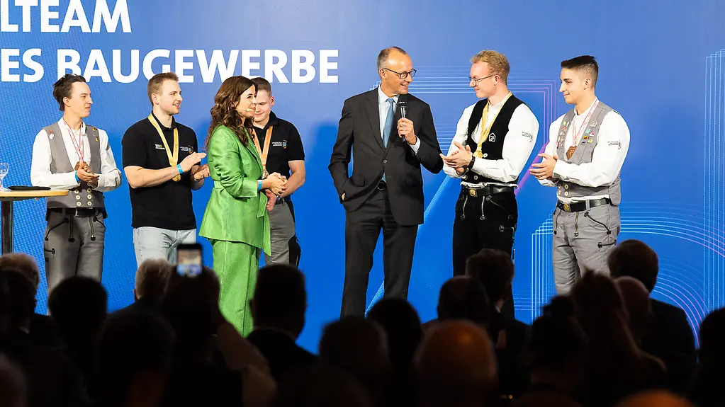 Bundeskanzler Merz mit Handwerkern des Nationalteams Deutsches Baugewerbe.