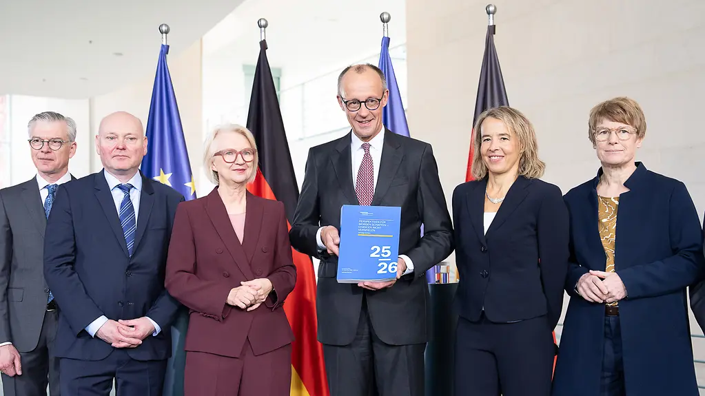 Auf dem Foto zu sehen sind Bundeskanzler Friedrich Merz und der Sachverständigenrat Wirtschaft bei der Übergabe des Jahresgutachtens 2025/26. 