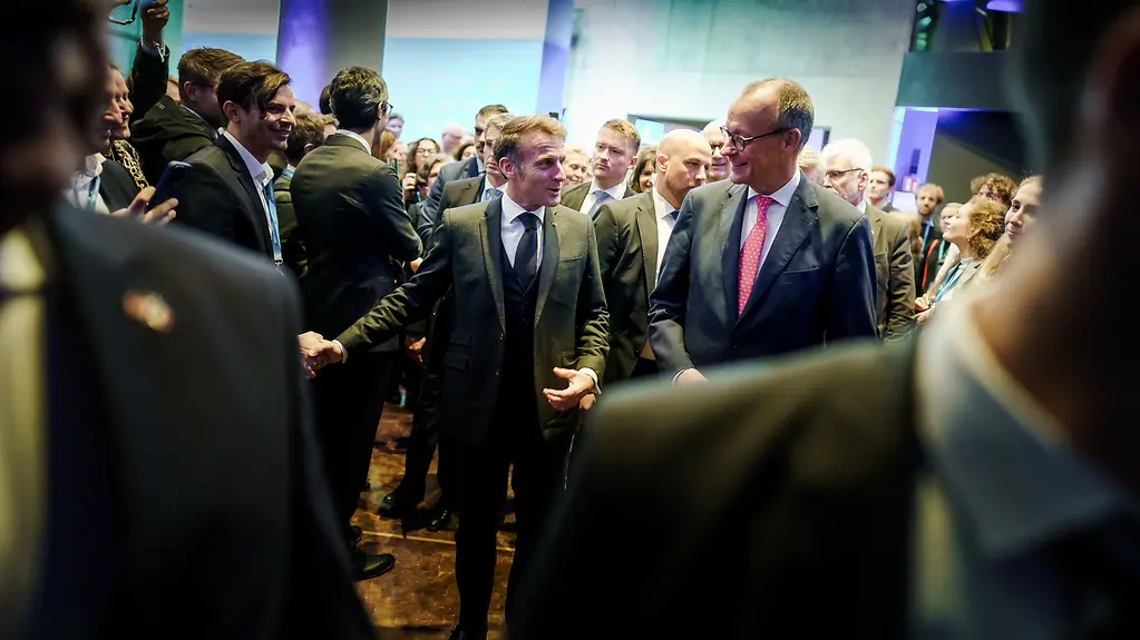Präsident Macron und Bundeskanzler Merz unter Teilnehmerinnen und Teilnehmern auf dem Gipfel zur europäischen digitalen Souveränität.