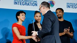 Das Foto zeigt Bundeskanzler Friedrich Merz bei der Verleihung des Preises "Talisman" an Malaika Mihambo.