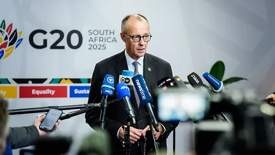 The photo shows Federal Chancellor Friedrich Merz making a statement at the G20 summit
