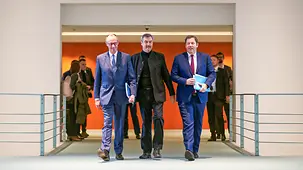 Das Foto zeigt Bundeskanzler Friedrich Merz zwischen Markus Söder und Lars Klingbeil.