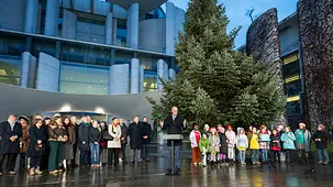 Das Foto zeigt Bundeskanzler Friedrich Merz bei der Übergabe des Weihnachtsbaums im Kanzleramt.