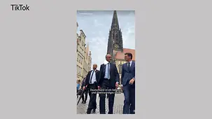 Das Foto zeigt Kanzler Merz mit dem Ministerpräsidenten von Nordrhein-Westfalen, Hendrik Wüst, beim Antrittsbesuch des Kanzlers im Bundesland. Dazu der Text: Deutschland ist ein liebens- und lebenswürdiges Land.