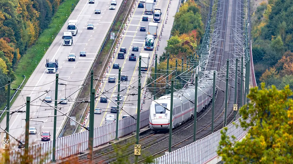 Train and motorway line next to each other.
