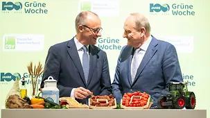 Das Foto zeigt Bundeskanzler Friedrich Merz beim Rundgang über die Grüne Woche mit Joachim Rukwied..