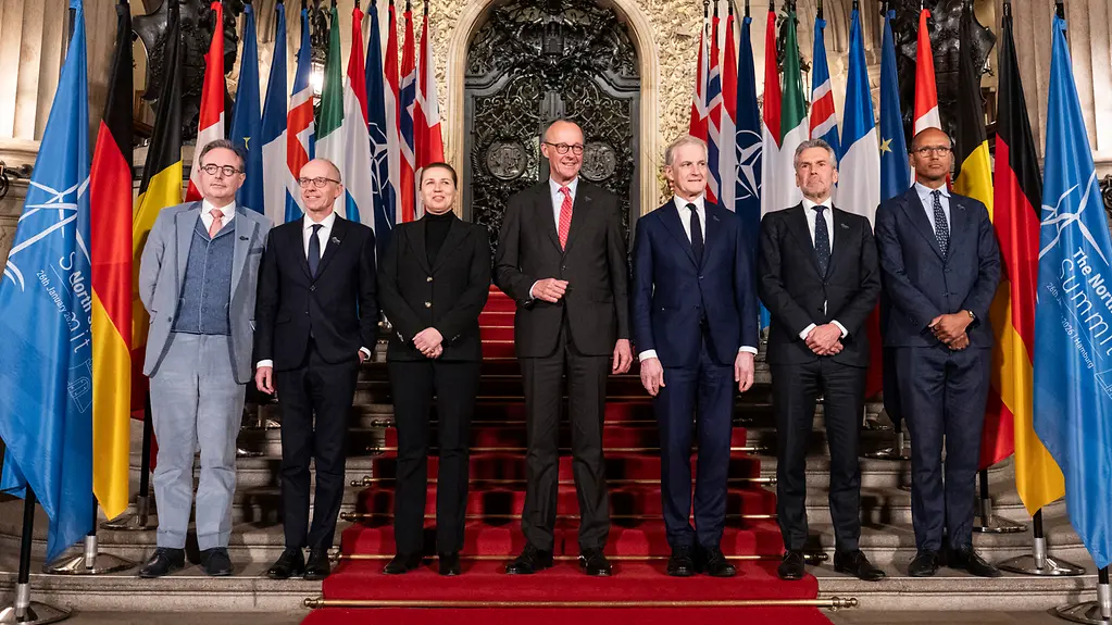 Family photo with Chancellor Merz and the participants of the North Sea Summit in front of Hamburg City Hall.