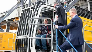 Das Foto zeigt Bundeskanzler Friedrich Merz im Gespräch beim Besuch der Firma Unternehmens Bauer International FZE.