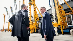 The photo shows Federal Chancellor Friedrich Merz in a conversation during his visit to Bauer International FZE.