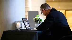 Das Foto zeigt Bundeskanzler Friedrich Merz, der sich in Kondolenzbuch für Rita Süssmuth im Bundestag ein.uth im Bundestag einträgt.