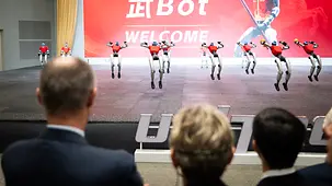 Das Foto zeigt Bundeskanzler Friedrich Merz bei einer Aufführung humanoider Roboter.