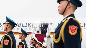 Federal Chancellor Merz disembarking from the government plane; in the foreground a Chinese guard of honour.