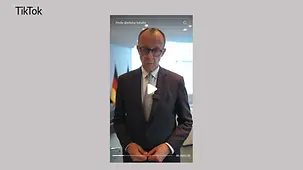 Halbnahe von Kanzler Merz in seinem Büro im Kanzleramt, er blickt in die Kamera.