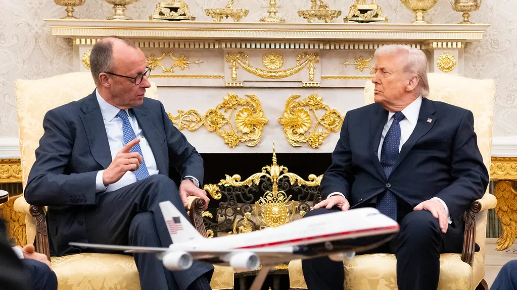 Das Foto zeigt Bundeskanzler Friedrich Merz im Gespräch mit US-Präsident Donald Trump.