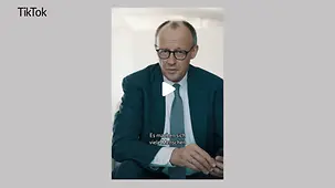 Bundskanzler Merz sitzt und spricht in die Kamera.