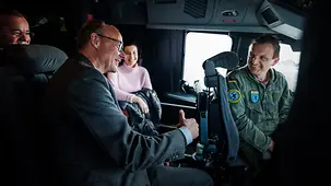 Bundeskanzler Friedrich Merz bin einem A400M im Gespräch mit dem Piloten.