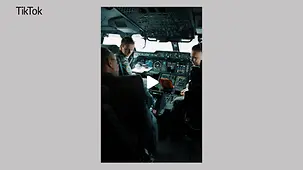 Bundeskanzler Merz im Cockpit eines Flugzeugs. Vor ihm sitzen zwei Piloten in Uniform der Luftwaffe.
