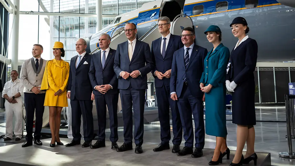 Gruppenfoto mit Bundeskanzler Merz, Verkehrsminister Schnieder, Lufthansa-Vorstand Carsten Spohr und anderen.