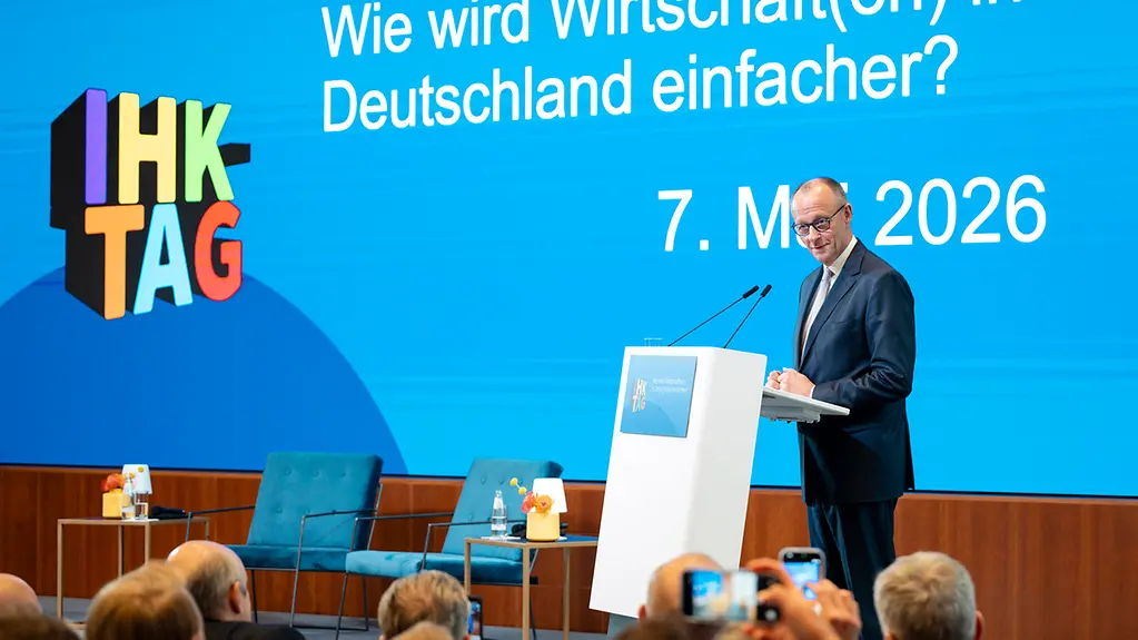Bundeskanzler Merz auf der Bühne hinter einem Rednerpult.