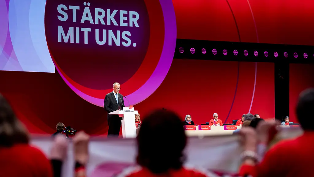Bundeskanzler Merz am Rednerpult beim DGB vor rot-lila Wand mit Aufschrift "stärker mit uns".