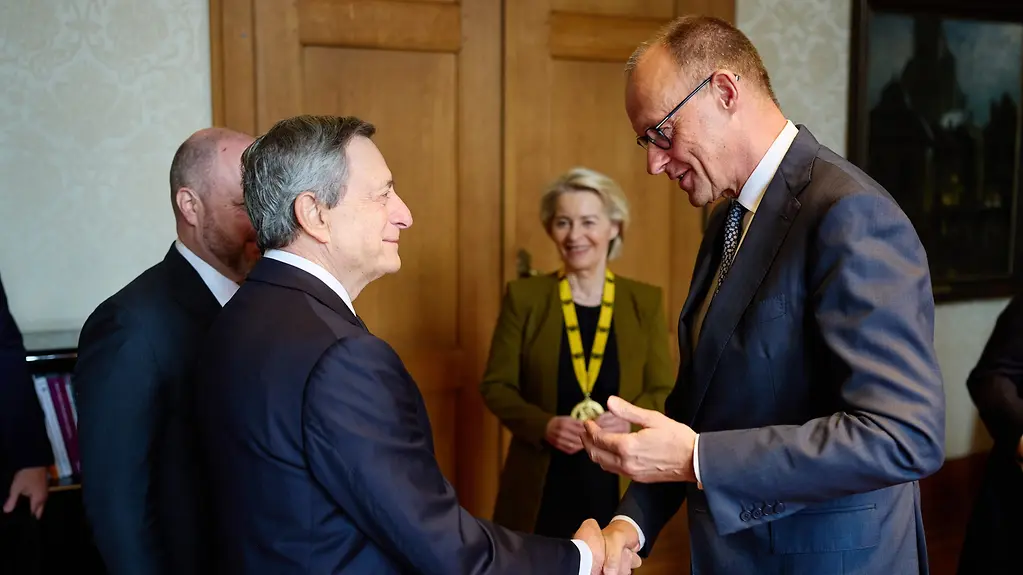 Kanzler Merz mit Karlspreisträger Mario Draghi und im Hintergrund EU-Kommissionspräsidentin Ursula von der Leyen