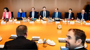Bundeskanzler Friedrich Merz und die Ministerinnen und Minister der Bundesregierung sitzen an einem Besprechungstisch.
