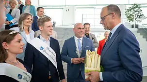 Bundeskanzler Friedrich Merz mit einer Kiste Spargel.