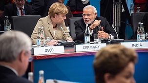 Bundeskanzlerin Angela Merkel unterhält sich mit dem indischen Premierminister Narendra Damodardas Modi.