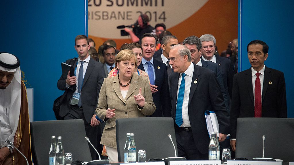 Bundeskanzlerin Angela Merkel kommt mit OECD-Generalsekretär José Ángel Gurría Treviño zur Auftaktsitzung der G20-Gruppe.