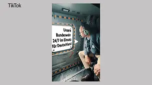 Kanzler Merz mit Headset in einem Flugzeug.