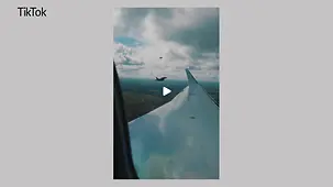 Blick aus einem Flugzeugfenster auf zwei Kampfjets der Luftwaffe.