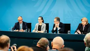 Bundeskanzler Friedrich Merz spricht bei einer Pressekonferenz neben Constanze Janda, Jürgen Weise und Bärbel Bas.