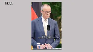 Bundeskanzler Merz an einem Mikrophon.