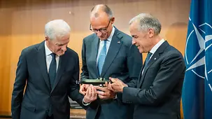 Chancellor Merz, Prime Minister Carney and Minister-President Støre is presenting a model submarine manufactured by TKMS.