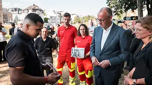 Bundeskanzler Merz im Gespräch mit Ehrenamtlichen.