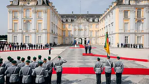 Vor dem Schloss Augustusburg empfängt Bundeskanzler Friedrich Merz den französischen Präsidenten Macron mit militärischen Ehren.