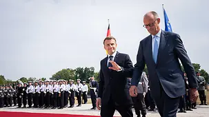 Merz und Macron beim Abschreiten der Ehrenformation.