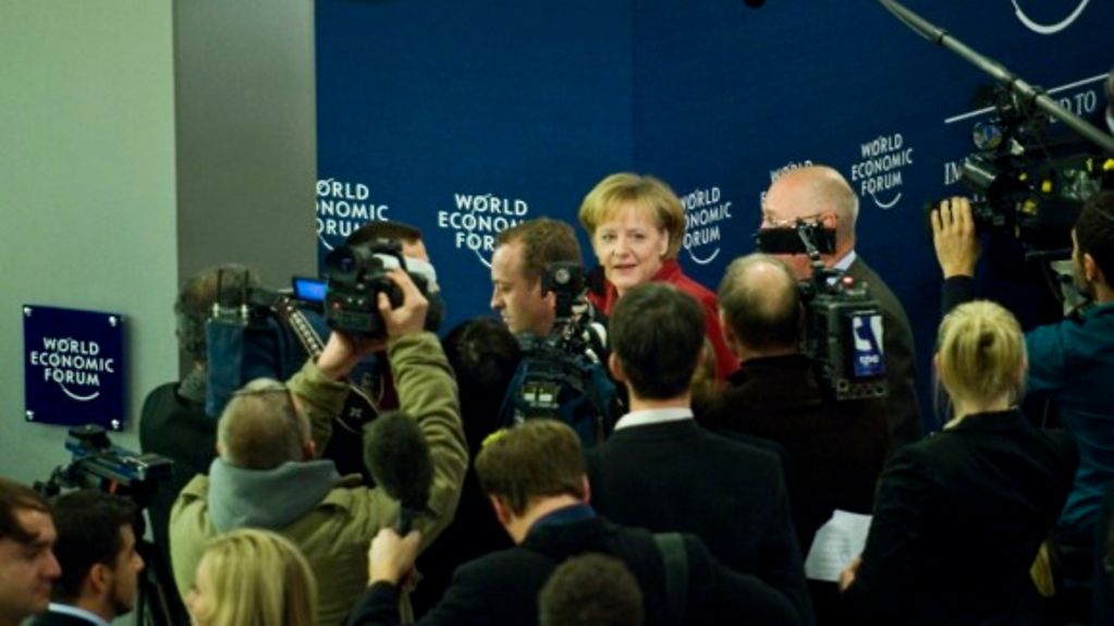 Angela Merkel auf dem Podium des Weltwirtschaftsforums, im Vordergrund Fotografen