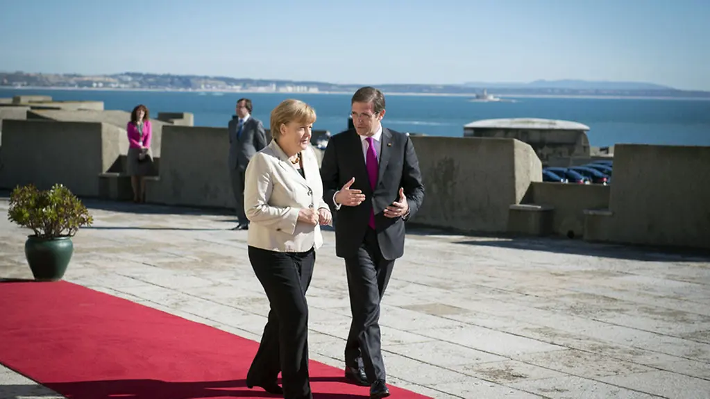 Angela Merkel is welcomed by Pedro Passos Coelho