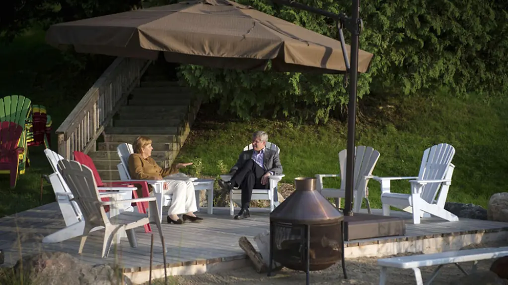 Angela Merkel and Stephen Harper talk on the patio of the Canadian Prime Minister's summer residence on Lake Harrington.