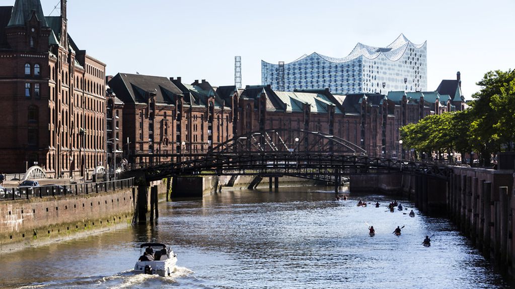 Die Speicherstadt in Hamburg - dahinter sieht man silbern das Gebäude vom Konzerthaus Elb-Philharmonie.