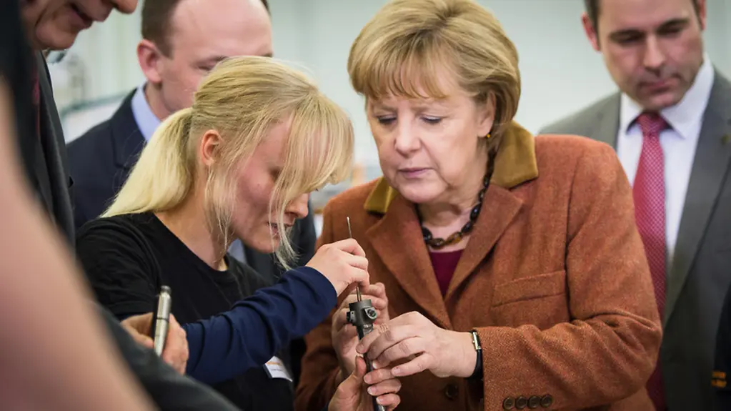 Angela Merkel and a staff member with an injector