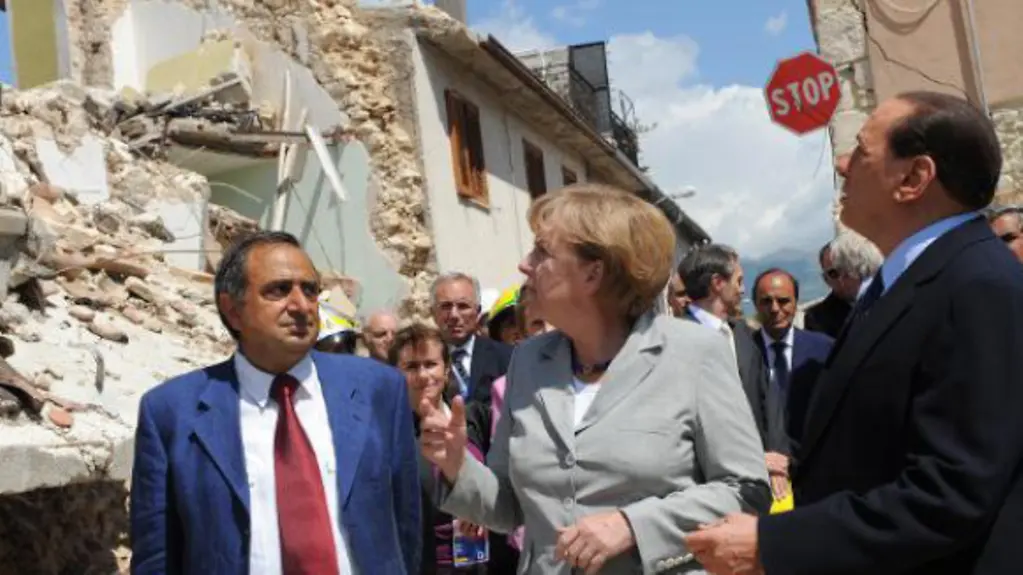 Angela Merkel and Silvio Berlusconi inspect the damage caused by the earthquake in Onna