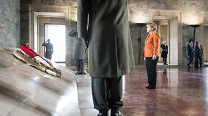 Chancellor Angela Merkel lays a wreath.