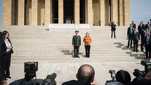 The Chancellor leaves the Atatürk Mausoleum with an officer of the guard of honour.